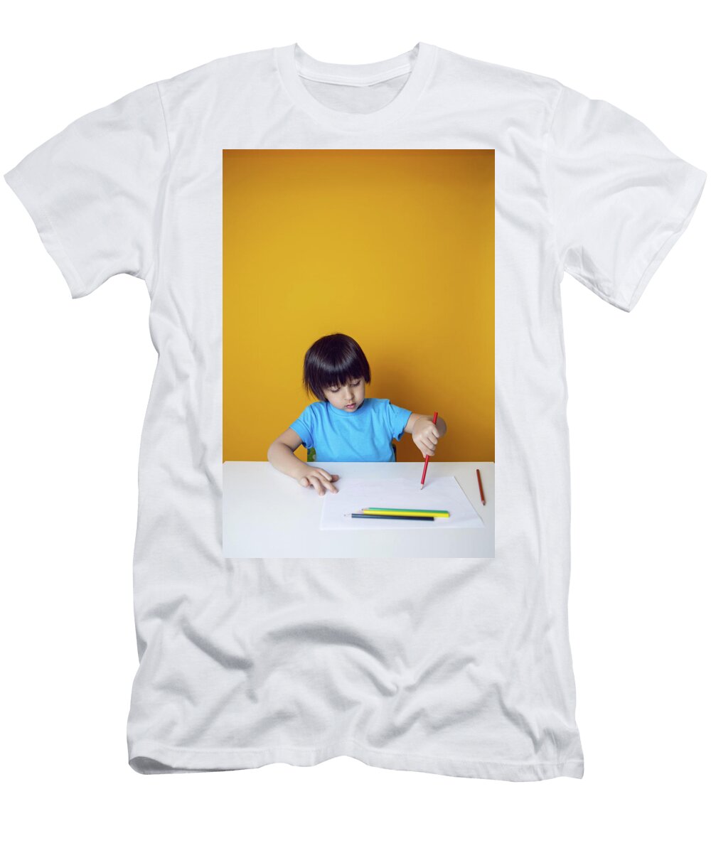 1 Boy Child in a Blue on a Yellow Background Sits At a White Table and Draws with Colored Pencils Elena Saulich T-Shirt