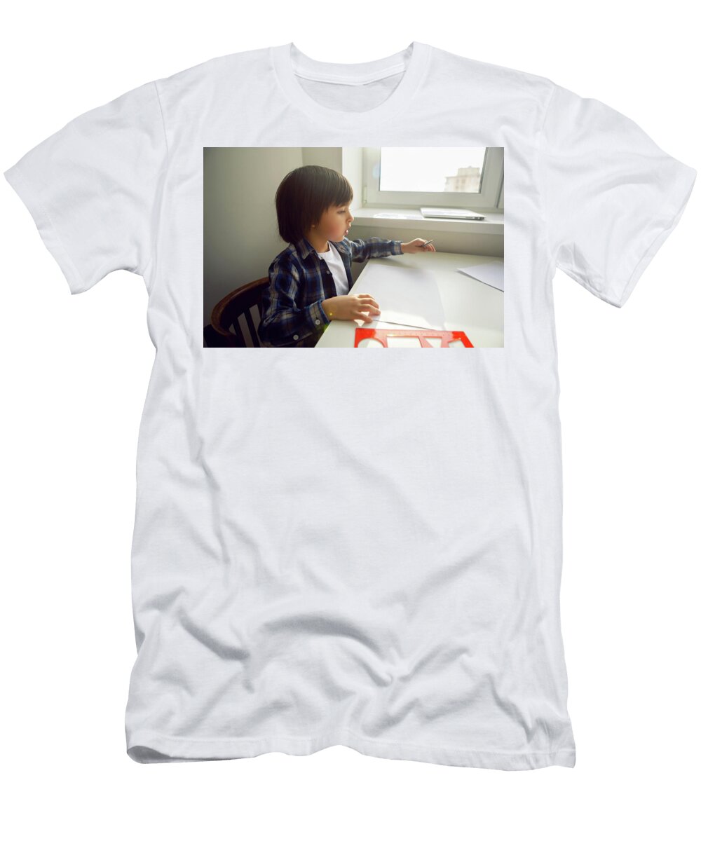 4 Boy Child Draws on Paper with a Ruler on a Table Sitting By the Window Elena Saulich T-Shirt
