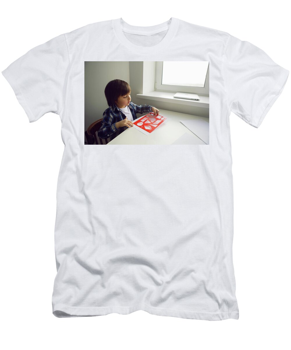 5 Boy Child Draws on Paper with a Ruler on a Table Sitting By the Window Elena Saulich T-Shirt
