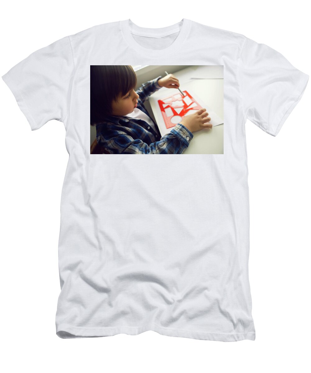 8 Boy Child Draws on Paper with a Ruler on a Table Sitting By the Window Elena Saulich T-Shirt